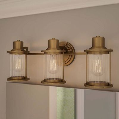 QUOIZEL Wall light Riggs IP44, antique brass, 3-bulb